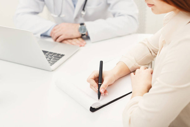 Patiënt schrijven van gegevens aan notitieboekje, close-up - Foto, afbeelding