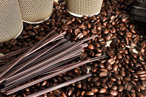 Una imagen de granos de café recién tostados con tazas de café y palitos de agitación
.  - Foto, Imagen