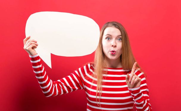 Young woman holding a speech bubble - Photo, image