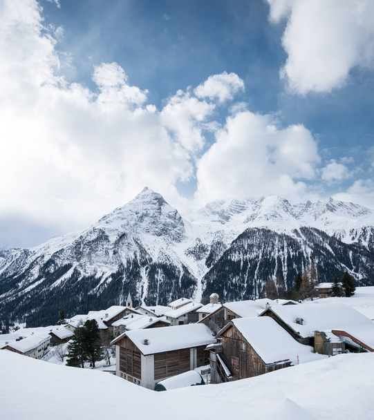 Dorp in de vallei van de berg van Zwitserland. Prachtige natuurlijke landschap op de wintertijd - Foto, afbeelding