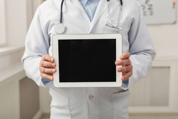 Κοντινό πλάνο του γιατρού κατέχει υπολογιστή tablet με μια κενή οθόνη - Φωτογραφία, εικόνα