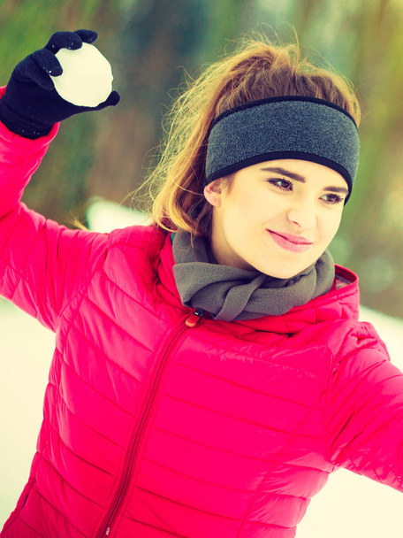 Woman wearing sportswear throwing snowball - Fotografie, Obrázek
