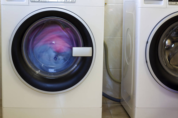 Színes ruhák és törölköző a mosógép - Fotó, kép
