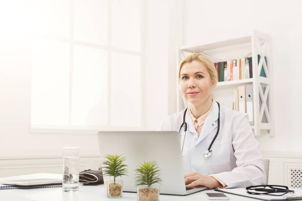 Portret lekarka siedzi przy pulpicie - Zdjęcie, obraz