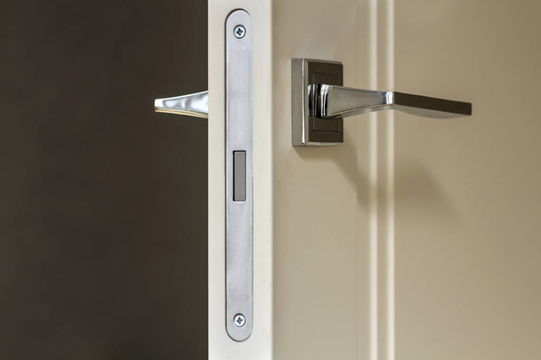 Klamka ze stali nierdzewnej nowoczesny na białe drzwi drewniane - Zdjęcie, obraz