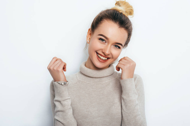 Cheerful young good looking woman with adorable smile hair bun posing on white isolated background. smiling broadly with her white straight teeth, laughing at good joke. People Emotions Beauty - Foto, Bild