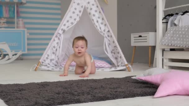 the child is sitting in the childrens room. crawls - Video