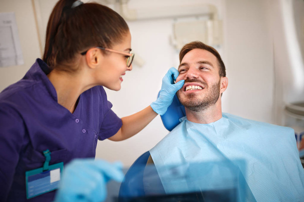 Zahnarzt schaut Patienten auf die Zähne - Foto, Bild