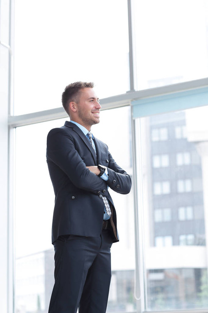 portrait of confident businessman looking out the window of the office. - Fotó, kép