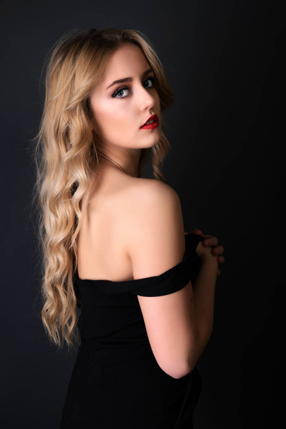 Blonde girl with long and volume shiny wavy hair . Beautiful woman model with curly hairstyle . - Fotografie, Obrázek