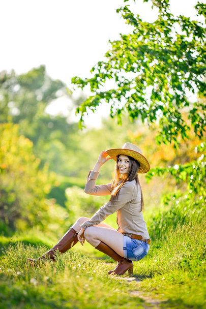 красива молода дівчина сидить на траві в саду
 - Фото, зображення