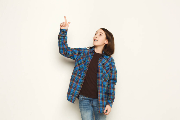 Menina animado mostra algo, apontar o dedo para cima
 - Foto, Imagem