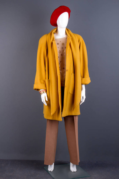 Maniquí vestido con un elegante abrigo amarillo
. - Foto, imagen