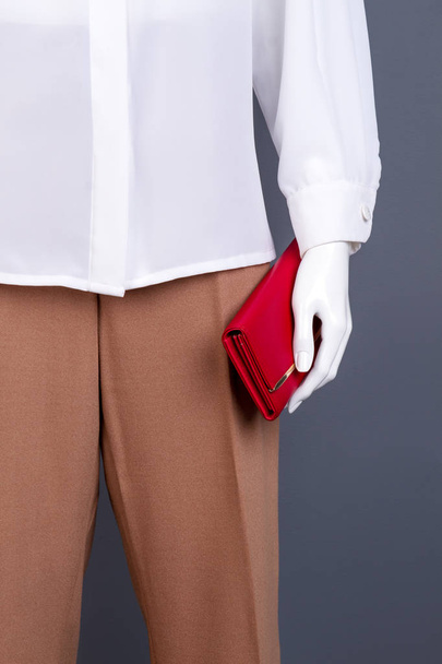 Female mannequin with red leather purse. - Valokuva, kuva