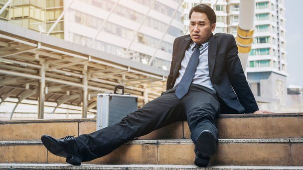 Отчаянный бизнесмен безнадежно сидит на лестничном полу
 - Фото, изображение
