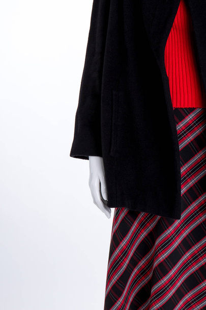 Close up black coat and striped skirt. - Foto, imagen