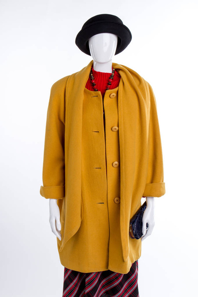 Chapeau noir et manteau jaune sur mannequin
. - Photo, image