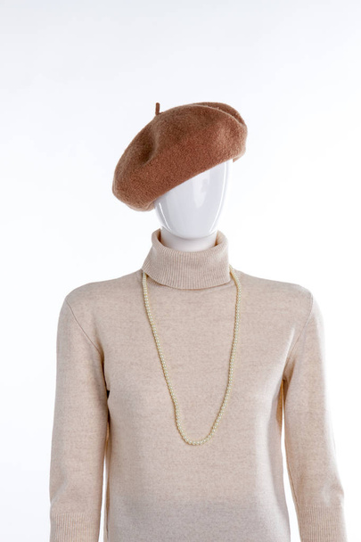 茶色のベレー帽とベージュ色のセーター. - 写真・画像