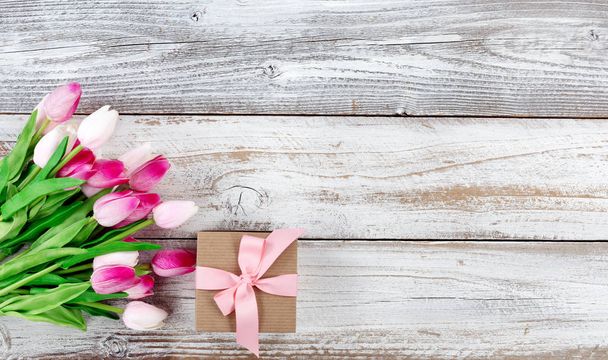 春ピンクのチューリップと白い素朴な木製ボードのギフト ボックス - 写真・画像