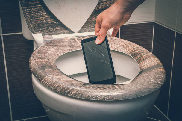 Femme jetant téléphone portable dans la cuvette des toilettes
 - Photo, image