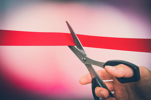 Mano con tijeras cortando cinta roja - ceremonia de apertura
 - Foto, Imagen