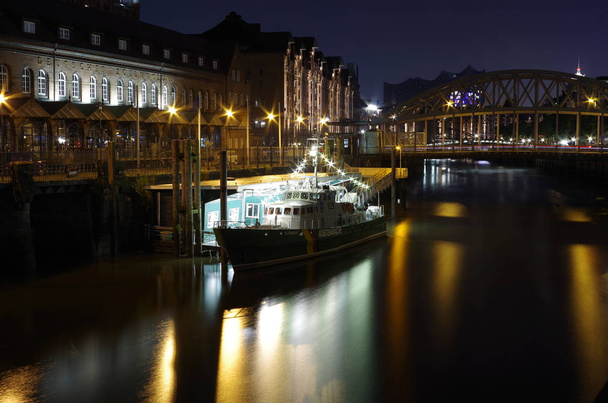 Hamburgo canal de aduanas con histórico barco de aduanas y puente en el fondo por la noche
 - Foto, imagen