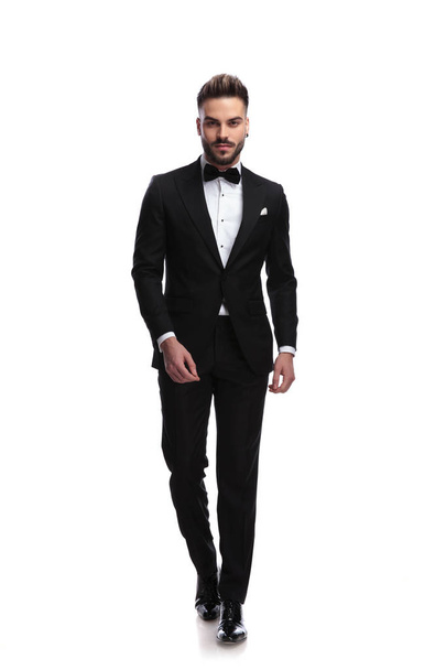 happy young male fashion model in tuxedo is walking - Photo, image