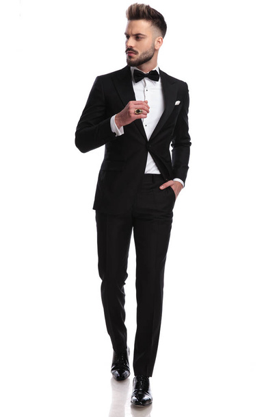 man in tuxedo wearing ring, walks and looks to side - Photo, Image
