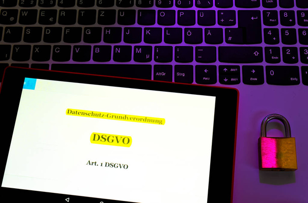 Laptop no qual o Regulamento Geral de Proteção de Dados (DSGVO) é exibido em inglês Basic Data Protection Regulation (GDPR) com um cadeado em óptica violeta
 - Foto, Imagem