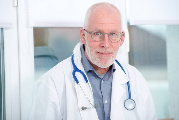 portrait of mature medical doctor with stethoscope - 写真・画像