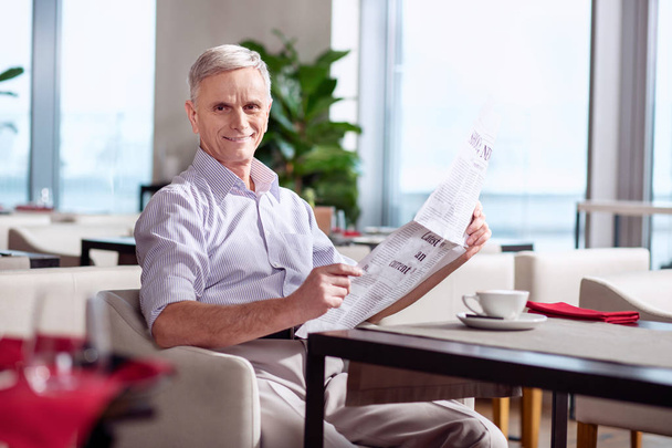 Cheerful mature man spending time with newspaper - Фото, зображення