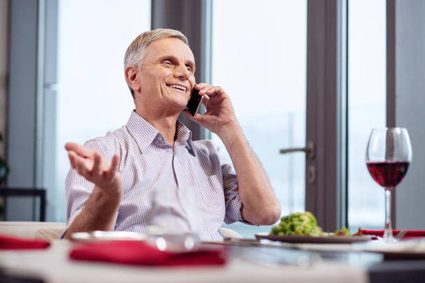 Cheerful mature man communicating on phone - Фото, зображення