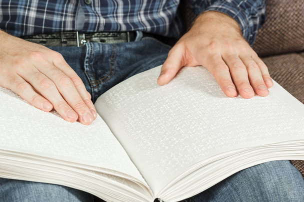 O cego estava lendo um livro escrito em Braille. Toque no seu dedo no código braille. Um livro com texto em Braille
. - Foto, Imagem