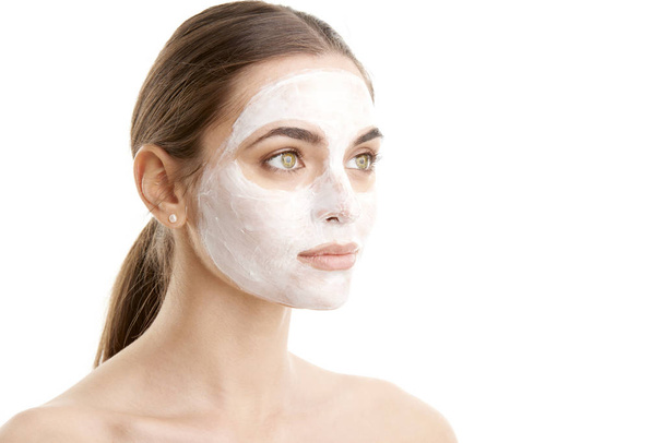Studioaufnahme einer jungen Frau mit Gesichtsmaske vor zumindest isoliertem Hintergrund mit Kopierraum.  - Foto, Bild