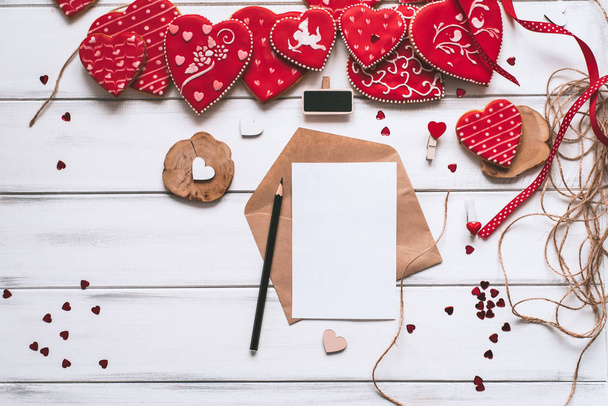 Sevgililer günü için el yapımı kırmızı sırlı Çerezler, mektup, kağıt parçası ve ahşap plakalar zemin üzerine kalem ile şenlikli kompozisyon. - Fotoğraf, Görsel