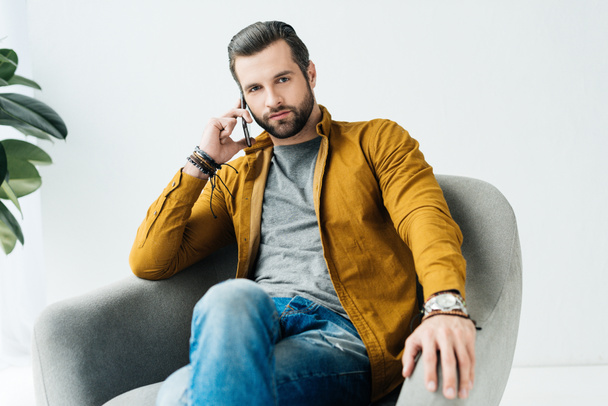 handsome man talking by smartphone and looking at camera - Fotoğraf, Görsel
