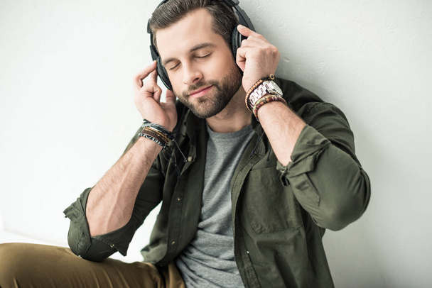 bonito homem ouvindo música com olhos fechados
 - Foto, Imagem