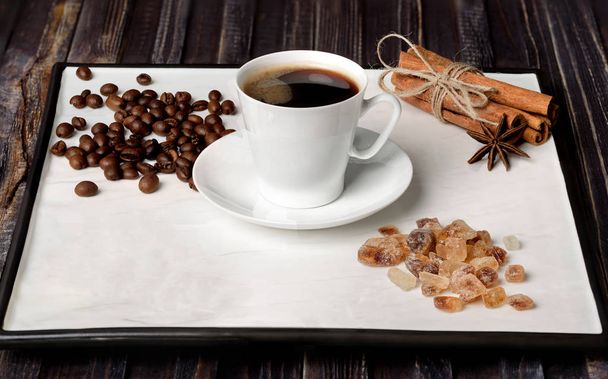 taza de café expreso, granos de café, azúcar y canela con anís sobre un fondo blanco
 - Foto, imagen