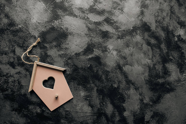 aranyos kis dekoratív birdhouse sötét kő háttér - Fotó, kép