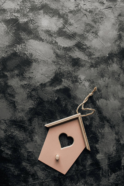 χαριτωμένο μικρό διακοσμητικό birdhouse σε σκούρο φόντο πέτρα - Φωτογραφία, εικόνα