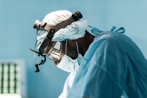 vue latérale du chirurgien afro-américain en salle d'opération
 - Photo, image
