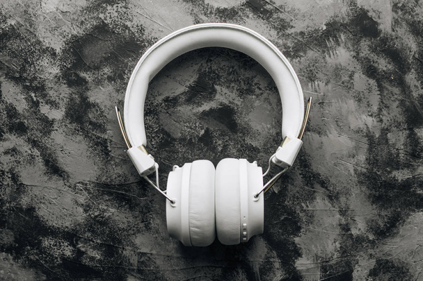 auriculares modernos blancos sobre fondo de piedra negra, blanco y negro
 - Foto, imagen