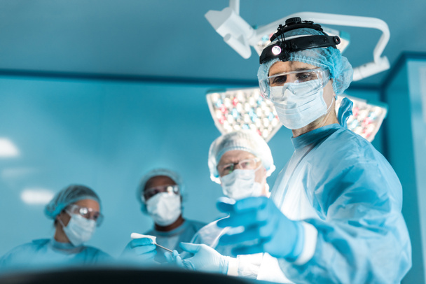 czterech lekarzy wieloetnicznym w sali operacyjnej - Zdjęcie, obraz