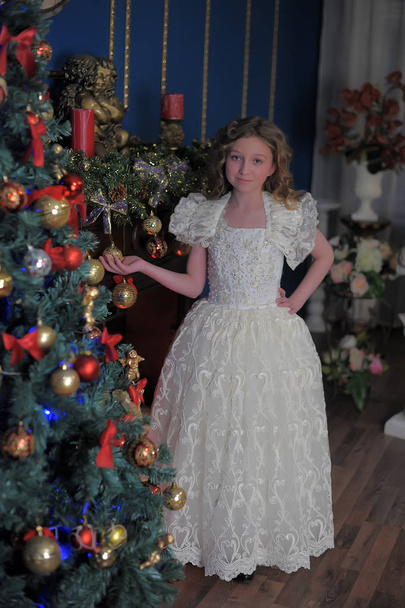 girl in a smart white dress at a Christmas tree - 写真・画像
