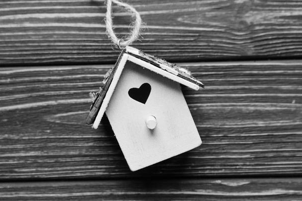 cute small decorative birdhouse on wooden planks background, black and white - Photo, Image