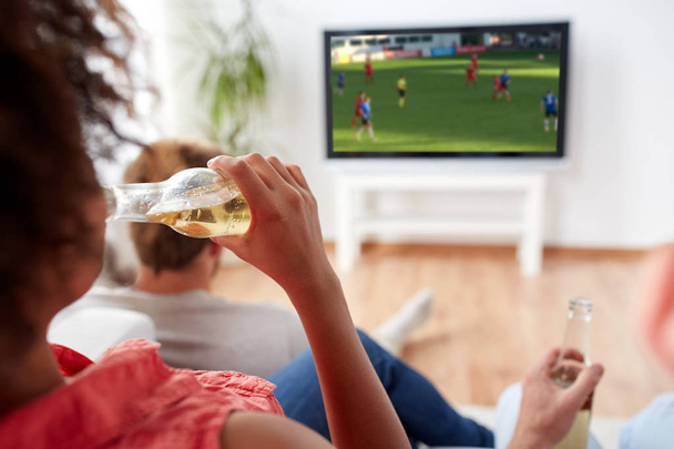 friends drinking beer and watching soccer on tv - Fotó, kép