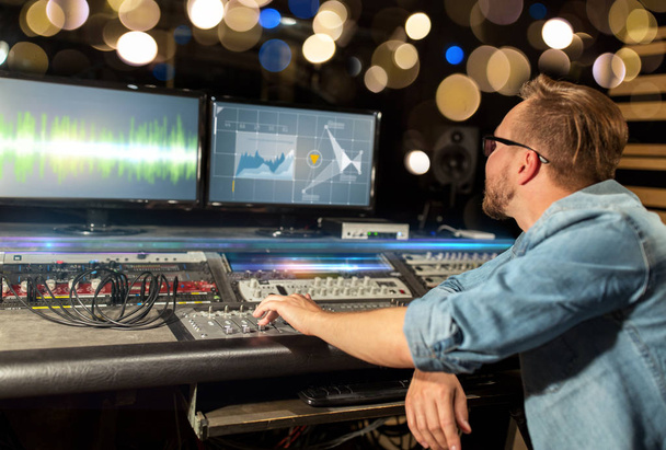 man at mixing console in music recording studio - Фото, изображение