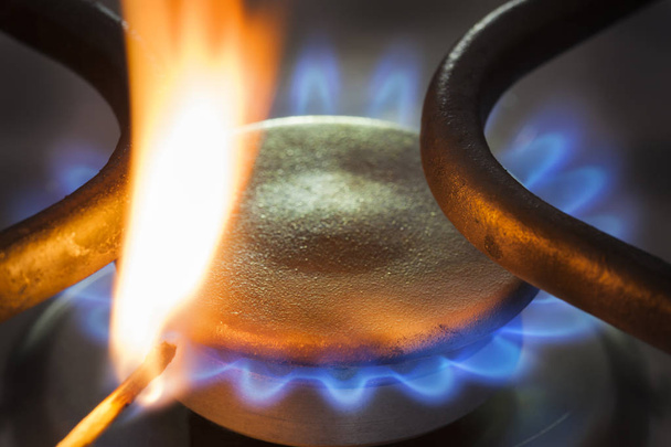 Para acender um queimador de gás natural com um fósforo
 - Foto, Imagem