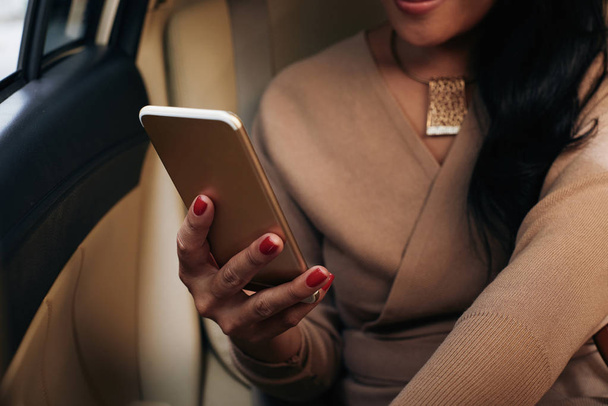 Smartphone takside oturan kadının elinde - Fotoğraf, Görsel