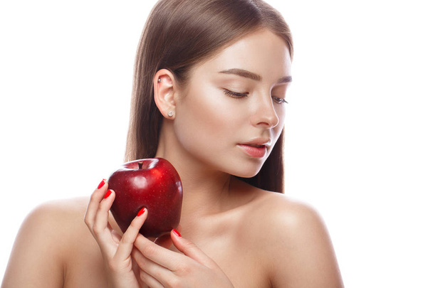 Beautiful young girl with a light natural make-up and perfect skin with apple in her hand . Beauty face. - Foto, Imagen